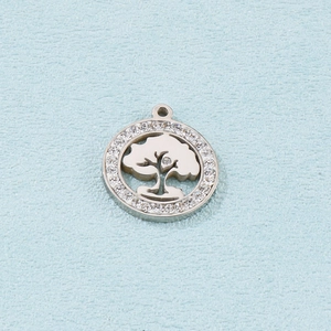 Close-up of a silver tree of life pendant with white crystals on a blue texture background