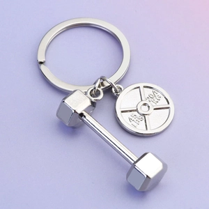 Porte-clés haltère en argent avec disques de musculation sur fond dégradé doux