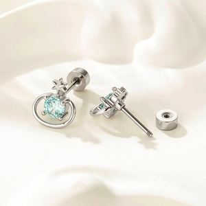Silver Saturn stud earrings featuring light blue zircon and celestial ring design