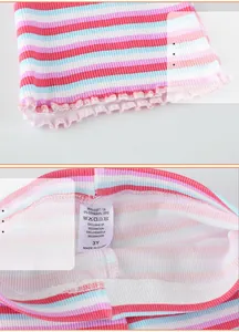 Detail of baby striped knit pants showing soft cotton fabric label and ruffled hem craft