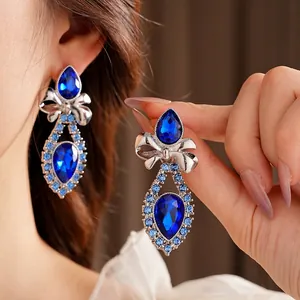 Vintage silver butterfly bow earrings with sapphire blue stones on elegant model