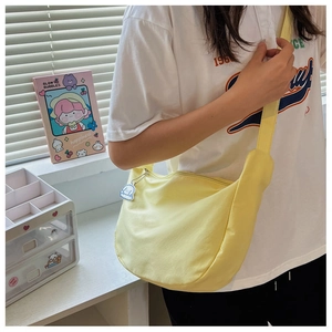 Detail of yellow crescent crossbody bag featuring smooth zipper and cute white cloud pendant