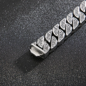 Macro shot of silver vintage totem engraved links and clasp on stainless steel bracelet