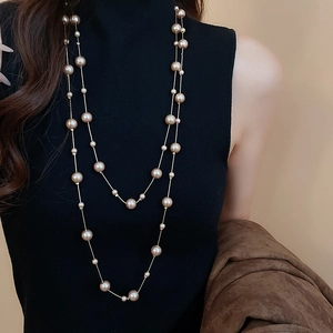 Detail of elegant double-layer pearl necklace on a black turtleneck sweater