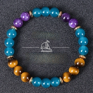 Detail of tiger eye and blue crystal beaded bracelet with Fortune text on black background
