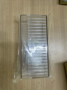 Macro view of clear acrylic jewelry storage box with individual compartment slots