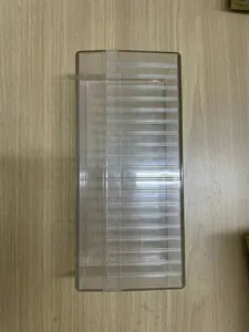 Macro view of clear acrylic jewelry storage box with individual compartment slots