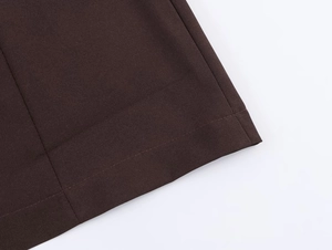 Gros plan détaillé de la couture de l'ourlet sur une robe plissée marron foncé