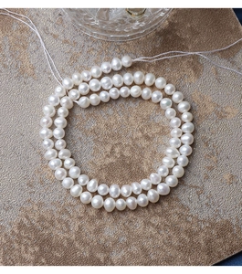 Macro view of 5mm natural freshwater pearls with lustrous finish on gold background
