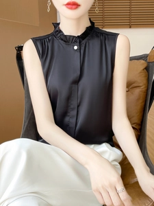 Close-up of black satin sleeveless top featuring a ruffled stand collar and pearl button