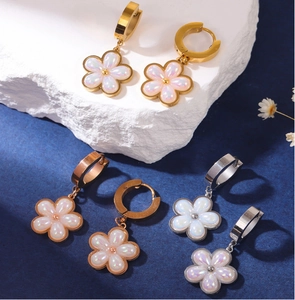 Three elegant flower earrings in gold rose gold and silver displayed on stone
