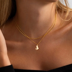 Gros plan détaillé d'un collier double rang plaqué or 18 carats avec pendentif chat