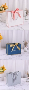 Detailed view of white, blue and silver luxury paper gift bags with satin bow ribbons