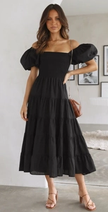 Detail of black tiered ruffle skirt and puff sleeves on summer off-shoulder midi dress