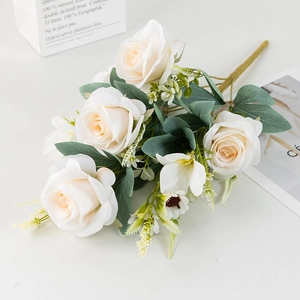 Detail of faux white roses bouquet with green leaves and realistic silk petals