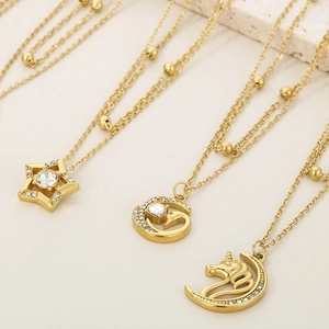 Detail of 18K gold-plated double-layer necklaces with star and unicorn crystal pendants