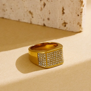 Macro detail of men's gold signet ring featuring a rectangular face set with pavé zircons
