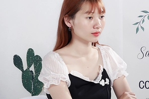 Close-up of a woman wearing black spherical glass drop earrings with stainless steel hooks