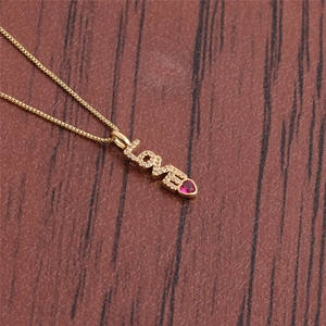 Golden LOVE letter necklace with sparkling crystals and a red heart gemstone pendant