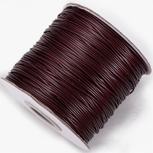 Macro detail of deep red waxed cord roll for jewelry making and DIY braided necklaces