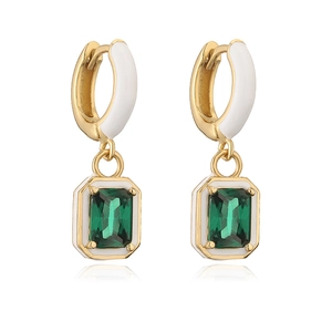 Detail of gold earrings featuring white enamel clasps and rectangular green gemstones