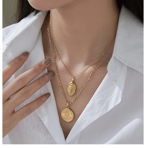 Close-up of double-layered 18K gold-plated titanium necklaces with vintage coin pendants