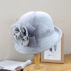 Détail d'un chapeau cloche en laine gris clair avec fleur 3D, résille et perles élégantes