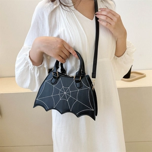 Detail of black bat-wing shaped handbag featuring white spider web stitching and PU texture