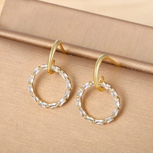 Macro shot of 14K gold plated earrings with circular clear cubic zirconia and silk texture