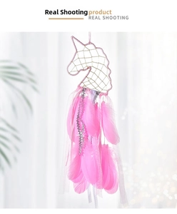 Detail of unicorn dream catcher with pink feathers, golden net, and silver sequins