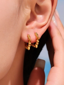 Détail de la créole en acier inoxydable plaqué or 18k avec finition en relief à pointes