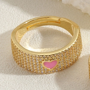 Close-up of gold-plated open ring featuring pavé zircons and a pink enamel heart design