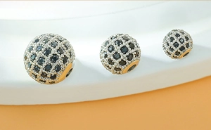 Macro view of micro-paved black zircon ball charms in three sizes for DIY bracelets
