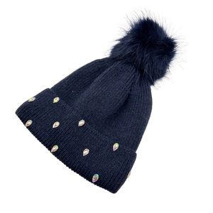 Macro detail of dark knit beanie featuring iridescent rhinestone studs and fluffy pom-pom
