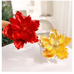 Close-up of red and gold Christmas flowers with glitter finish for holiday tree decoration