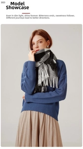 Detailed view of striped plaid scarf with thick white tassels and soft cashmere-like texture