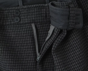 Detail view of dark grey plaid woolen skirt featuring double button waist and zipper