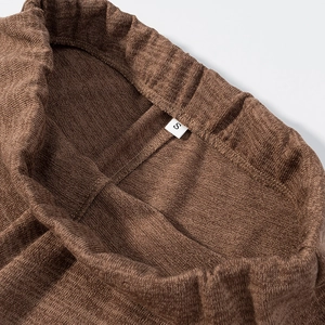Detaillierte Makroansicht der braunen Strickstruktur und Größe S Etikett am Gummibund