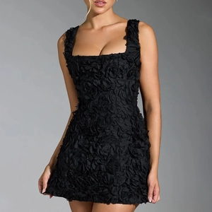 Détail de la texture rose 3D sur une robe mini noire moulante avec une encolure carrée