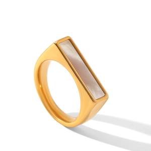 Macro detail of a gold stainless steel ring featuring a rectangular white shell inlay