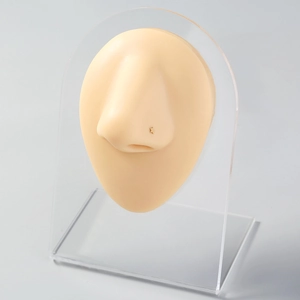 Star-shaped stainless steel nose stud shown on a silicone model with acrylic display stand