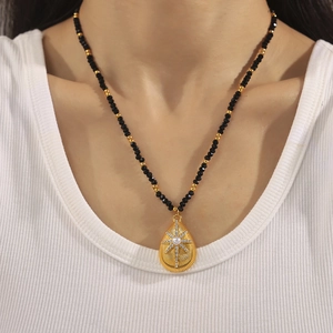 French style starburst pearl pendant necklace with black faceted beads and gold accents