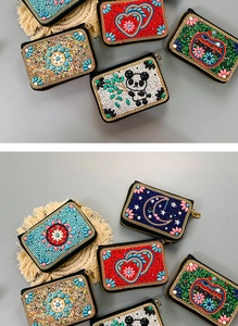 Detailed view of handmade beaded card holders with panda and floral motifs on woven mats