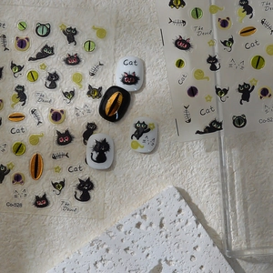 Detail of DIY gothic cat nail stickers featuring black kitten, fishbone and star designs