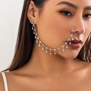 Detail of silver nose ring chain with rhinestones and fringe on model's face