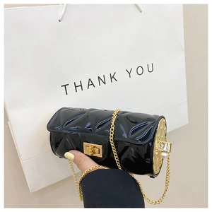 Close-up of black quilted cylinder jelly bag with gold chain and pearl detail