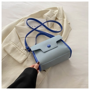 Close-up of litchi texture on light and dark blue contrast crossbody handbag