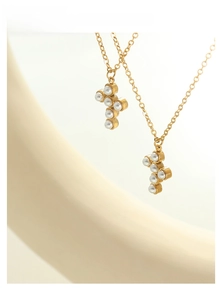 Macro shot of French style faux pearl cross pendant necklaces with gold finish chain