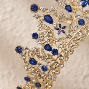 Close-up of gold bridal crown featuring blue and white rhinestones in leaf patterns