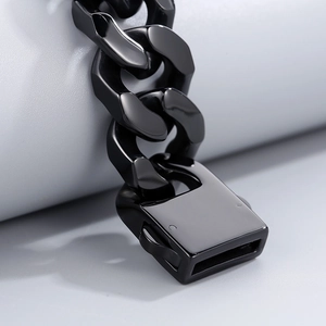 Macro shot of polished black stainless steel cuban link bracelet with clasp detail